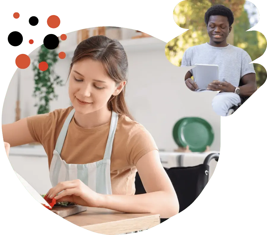 A disabled woman in her wheelchair slicing something in the kitchen and a disabled man holding his tablet